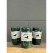 Three green bottles with labels on a gray surface