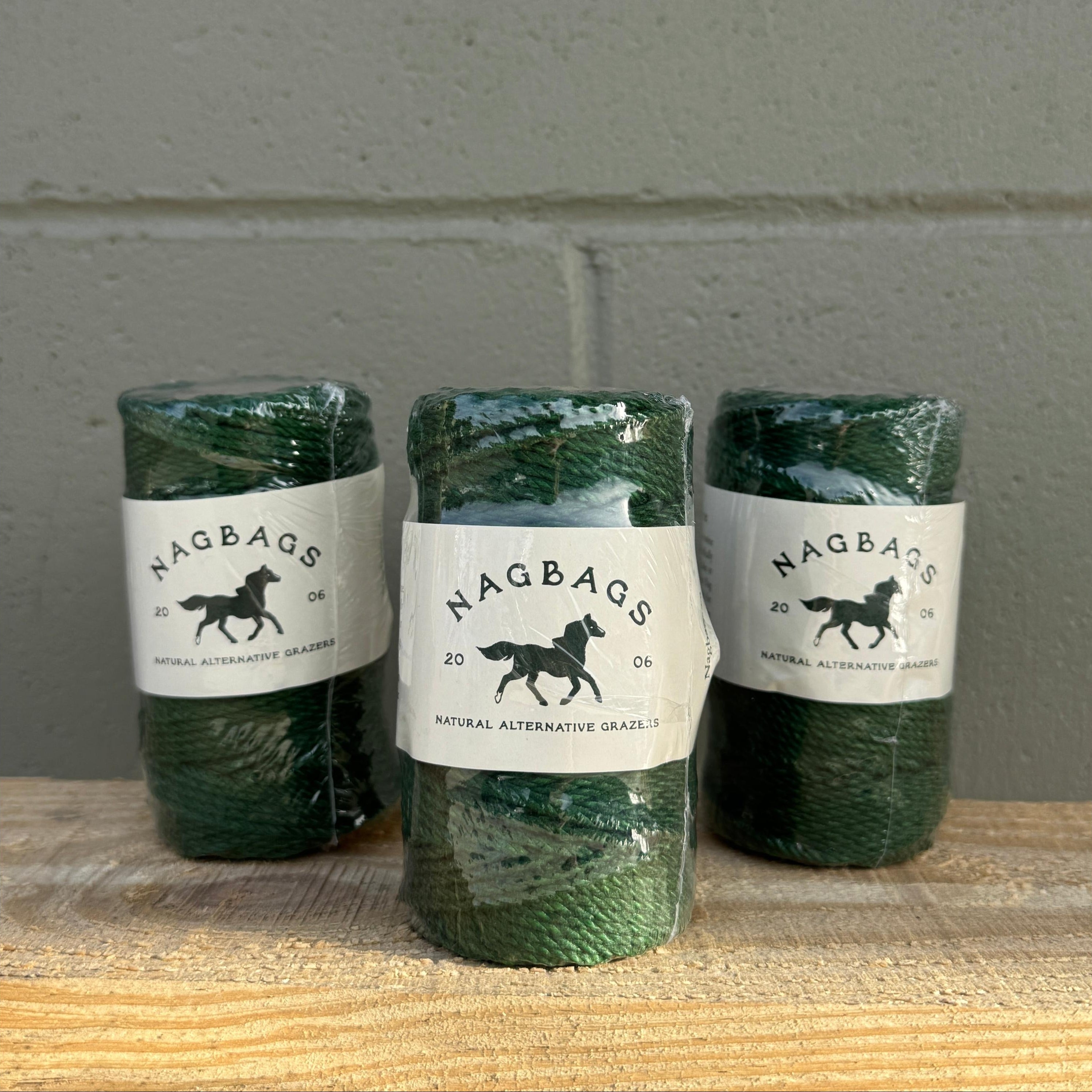 Three green bottles with labels on a gray surface
