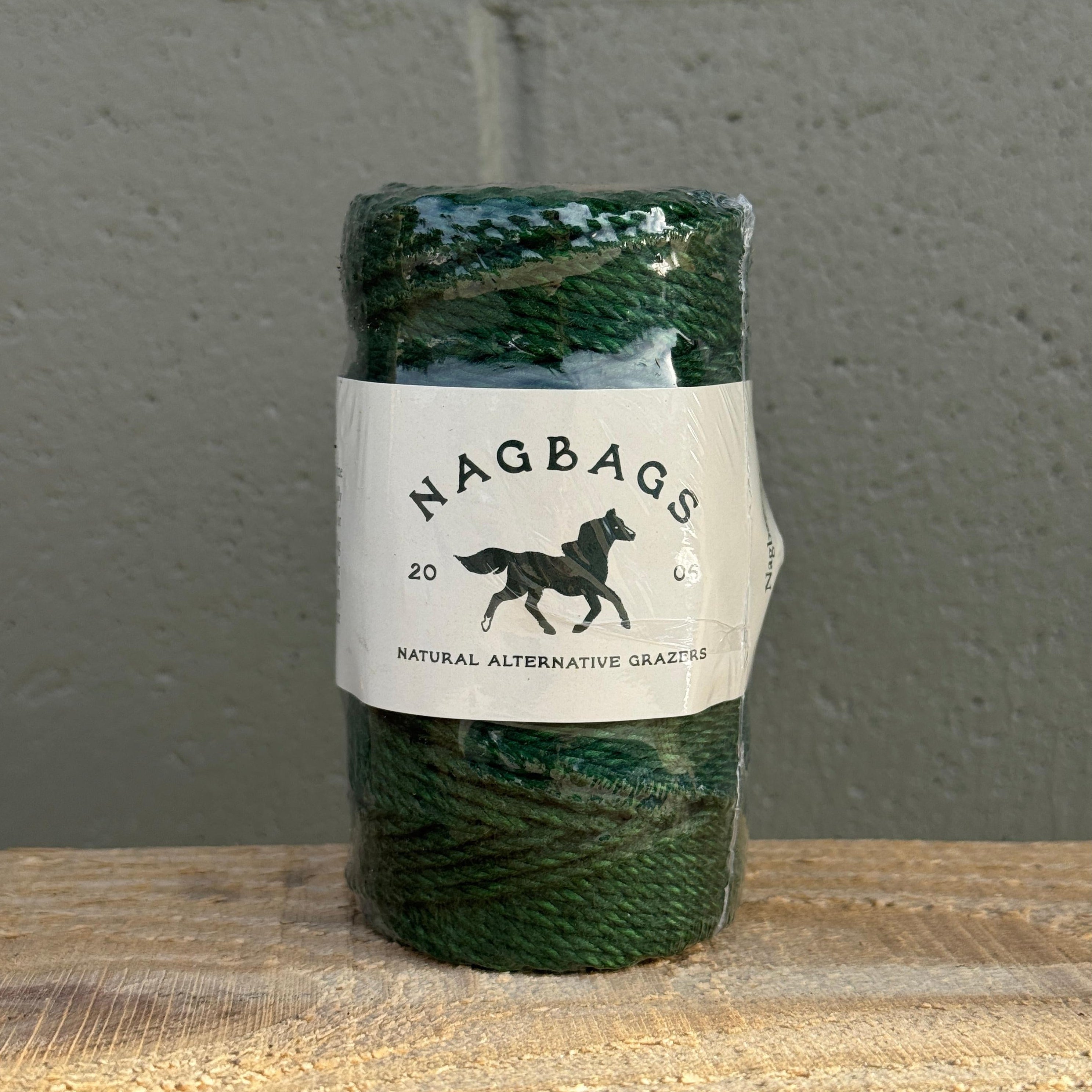 Green skein of yarn with a label on a gray and wooden surface