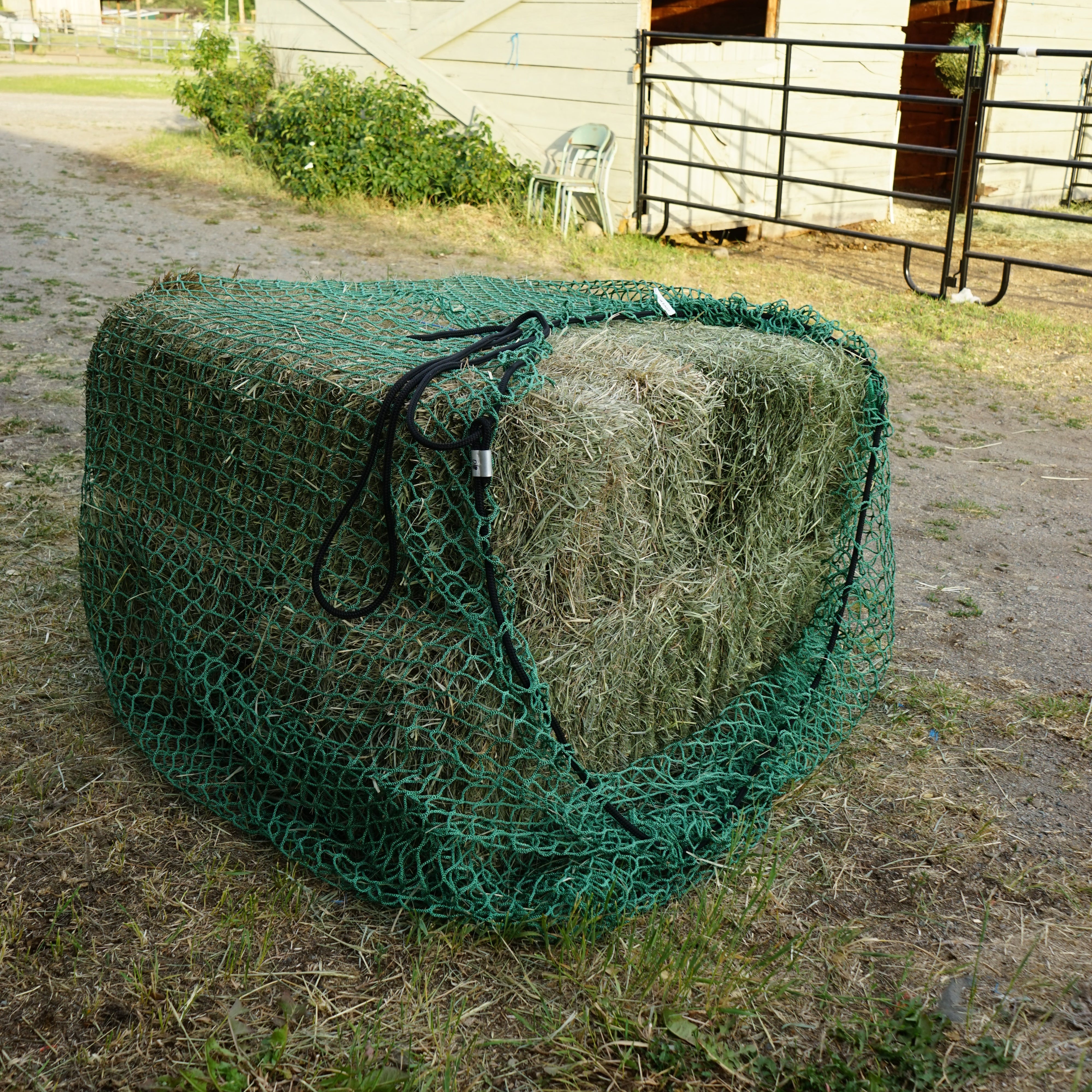 square bale feeder holding four bales in green netting 