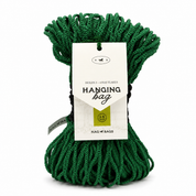 A green hanging bag hay net made of braided rope, bundled with a white paper tag that reads 'Hanging bag' and shows the Nag Bags logo, on a white background.