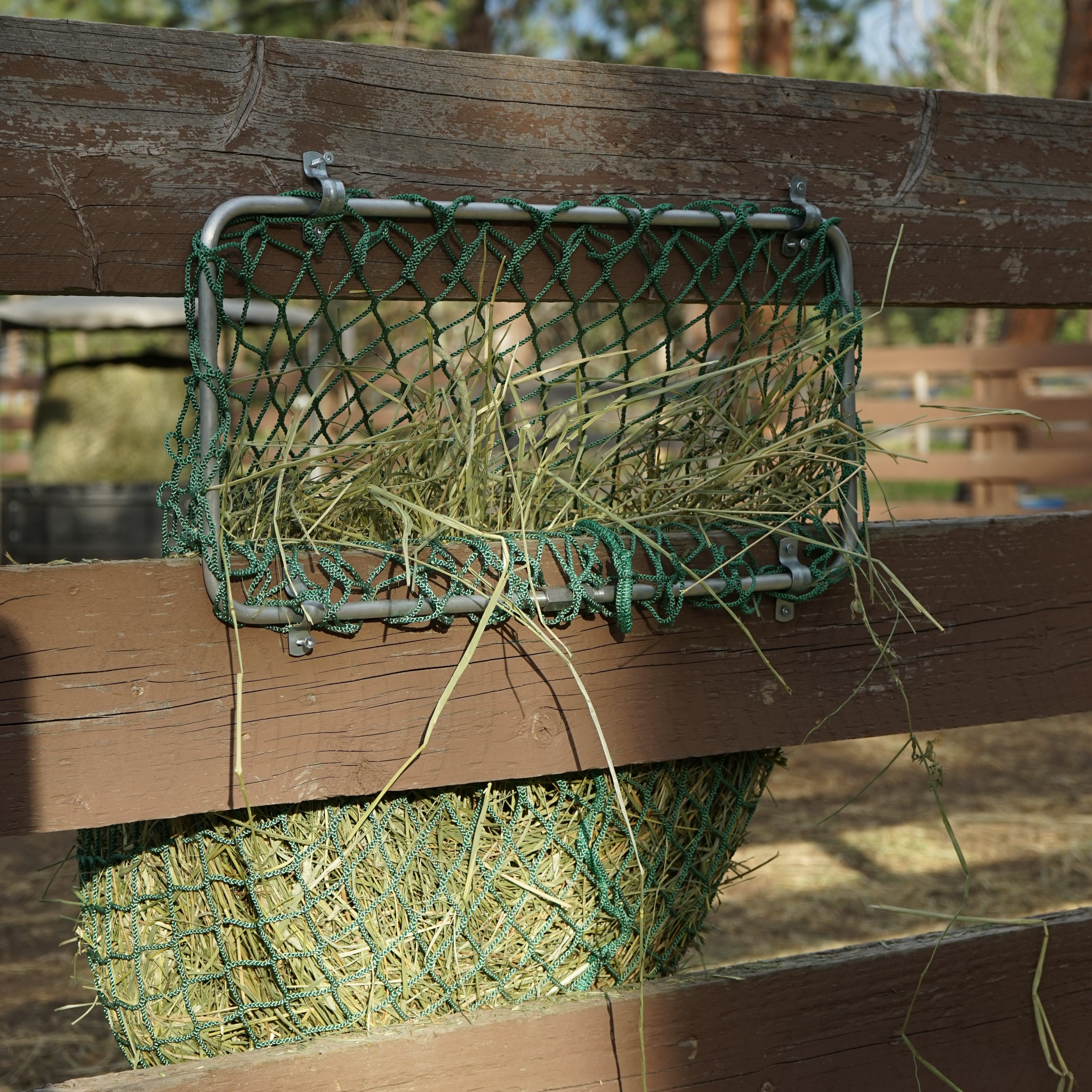 green hay net mounted on a wooden fence 