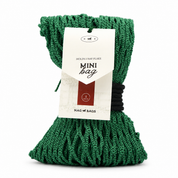 A green knotted rope bag with a white paper hangtag reading 'MINI bag' and 'NAG BAGS', photographed on a clean white background.
