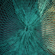 Close-up of a textured teal fabric with a starburst pattern on a black background