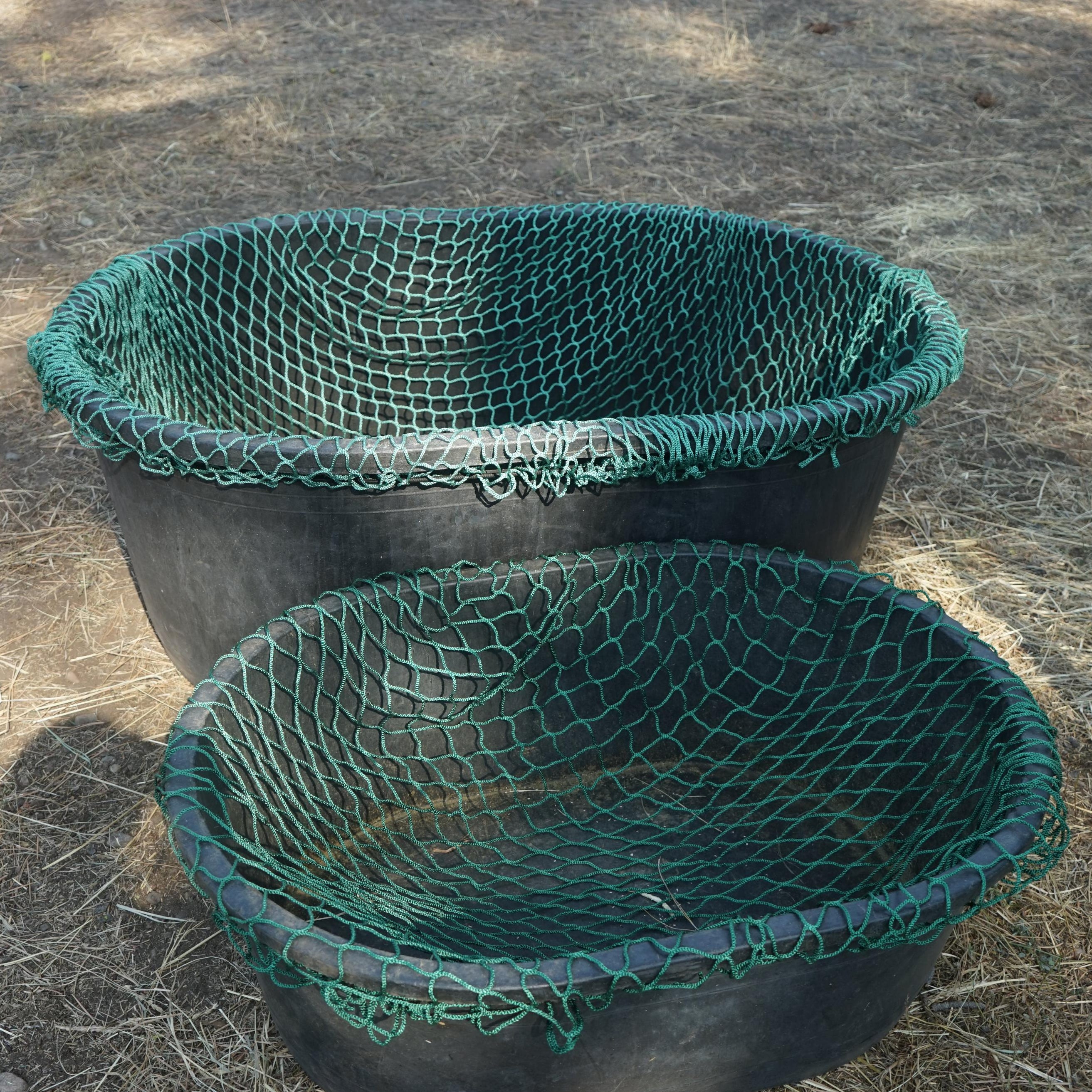 Two green netted bowls on a textured surface